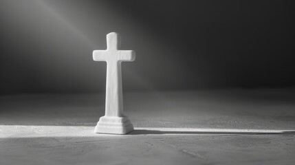 Naklejka premium A white cross is standing on a concrete floor. The cross is surrounded by a shadow, which gives the image a solemn and somber mood