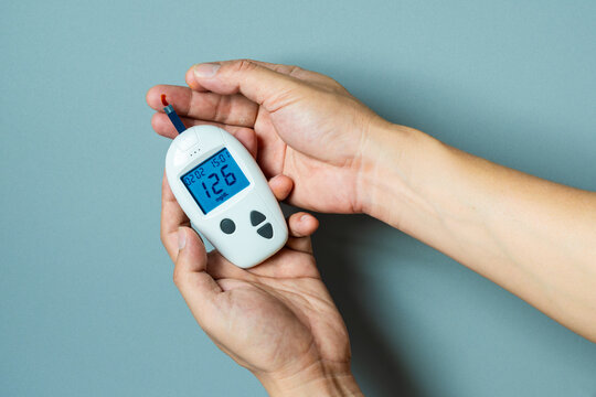 hand of people check diabetes and high blood glucose monitor with digital pressure gauge. Healthcare and Medical concept	