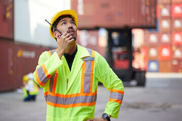 worker or engineer using walkie talkie and talking about work in containers warehouse storage