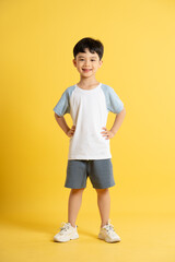 Full body image of asian kid boy wearing summer clothes posing on yellow background © STOCK88PHOTOGRAPHER