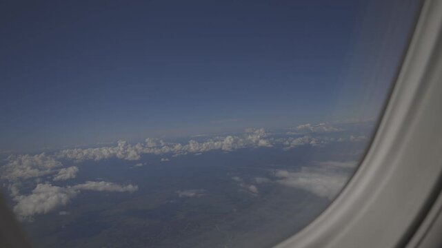 view from an airplane window, beautiful white clouds from above, captured canon eos R, raw c-log 8bits colour.