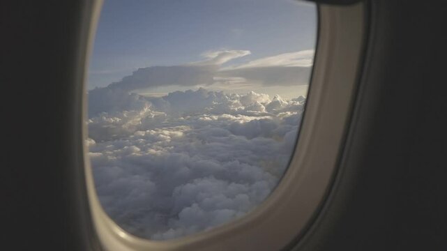 view from an airplane window, beautiful white clouds from above, captured canon eos R, raw c-log 8bits colour.