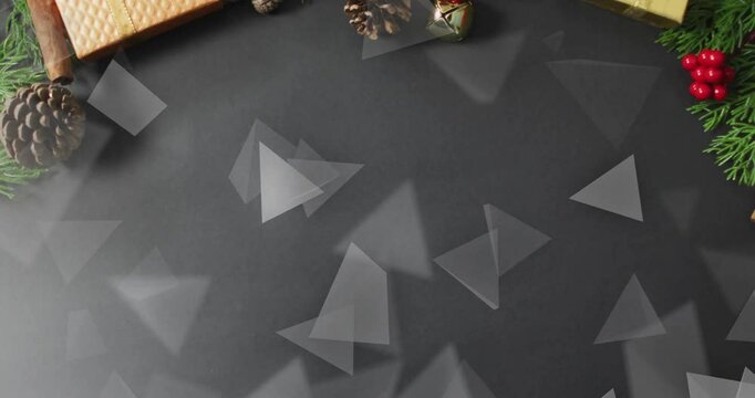 Christmas decorations with gifts and pinecones over floating triangles animation