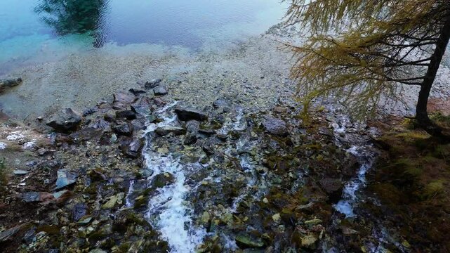 Waterstream going in the mountain lake "Lac Bleu" in Wallis Switzerland