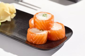 Luxurious Philadelphia Salmon Roll on Black Plate with Crisp White Background