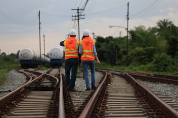 Senior male and female railway engineers are inspecting the railroad tracks for maintenance and improvements to ensure safe transportation of goods.