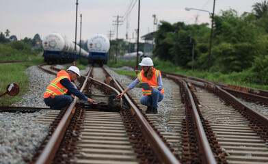 Senior male and female railway engineers are inspecting the railroad tracks for maintenance and...