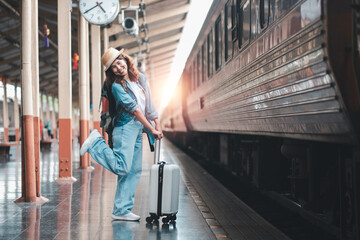 Cheerful young woman with a suitcase at a train station, excited for her journey. Perfect for travel, adventure, and transportation themes.