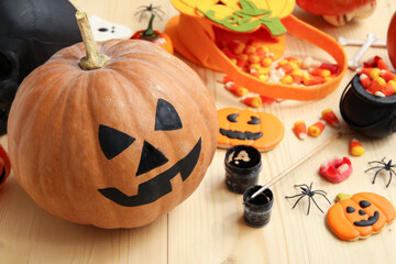 Painted pumpkin and Halloween decorations on wooden table
