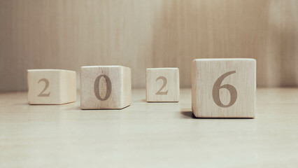 Number 2026 on wooden box for new year and business target concept. Number 2026 on natural wood cube