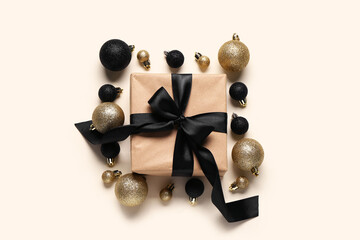 Gift box and Christmas balls on beige background