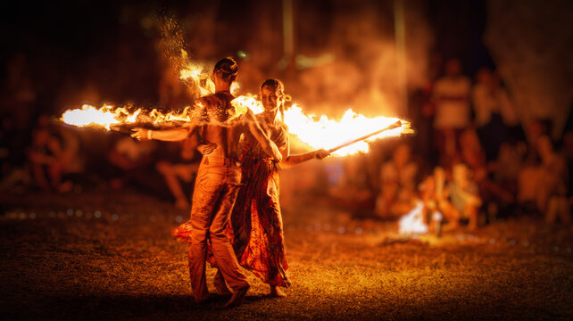 The enchanting fire dancers beautifully showcase their talent with fascinating flames during the performance.