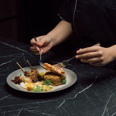 hand holding a plate with grilled chicken