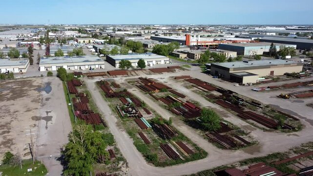 Drone shot of rusty pipes at an open-air warehouse in Calgary's industrial area.