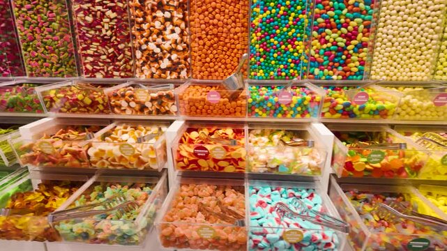 Colorful candy assortment displayed in clear bins at a candy store with vibrant, playful colors