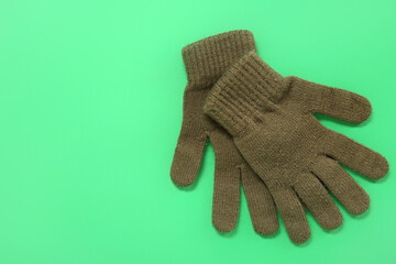Pair of winter gloves on green background