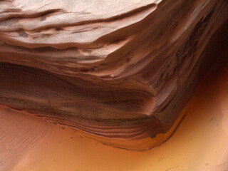 Buckskin Gulch canyon red rock layered sandstone wall and mud water puddle after the rain