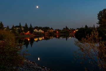 Night lights reflection in calm water of the lake