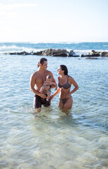 Young Happy family playing in the ocean