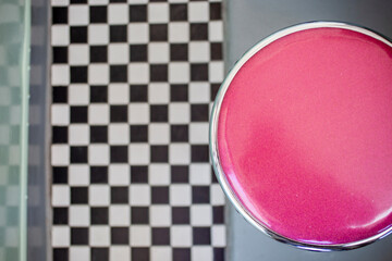 Overhead looking down on magenta stool and checkered floor