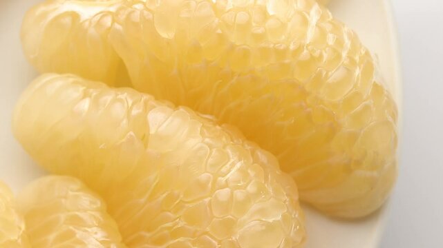Top view of yellow pomelo pulp texture rotating