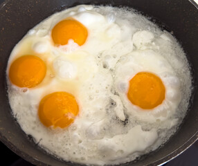 A pan of eggs is cooking on a stove