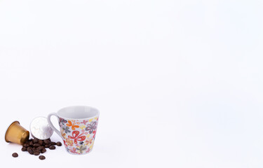 Coffee Pleasure: Golden Capsules and Coffee Cup Surrounded by Beans