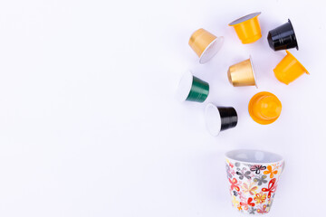 Top view of a white cup and assorted coffee capsules on a white background colorful caffeine choice for an energizing start