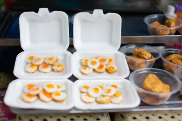 Fried quail eggs placed in a foam box ready to eat