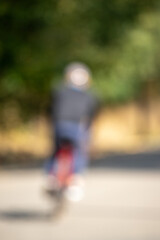 A blurry image of a person riding a red bike