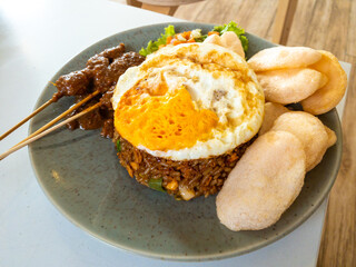 close up fried rice with egg, satay, pickles and crackers. Nasi goreng spesial from indonesia favorite food and delicious