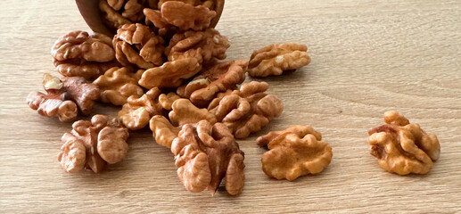Walnut kernels and whole walnuts on rustic old wooden table