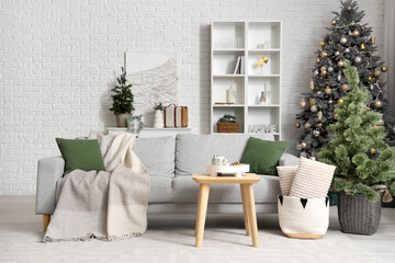 Stylish interior of modern living room with beautiful Christmas trees