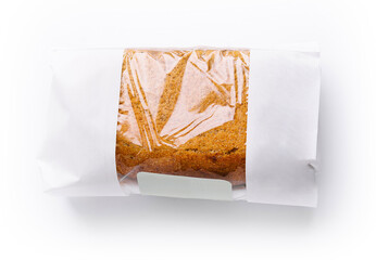 Freshly baked loaf of bread in minimalist packaging on white background