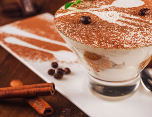 Delicious tiramisu dessert with coffee beans on top being served on white plate