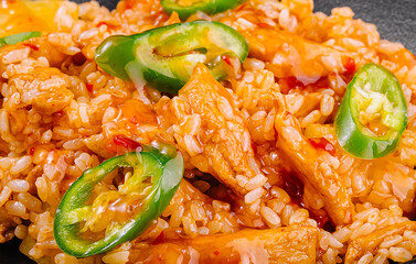 Spicy chicken and rice dish garnished with sliced jalapenos