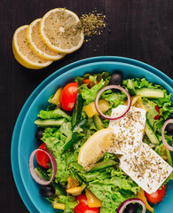Greek salad with feta cheese served in a blue bowl