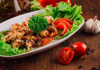 Roasted chicken breast with vegetables on a plate, garnished with herbs