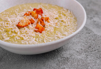 Broccoli cream soup being served with croutons and grated parmesan cheese