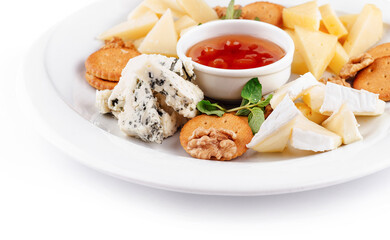 Delicious cheese plate presenting variety of cheeses, nuts, and sauce