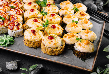 Delicious assorted sushi platter on dark stone background