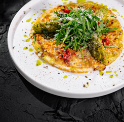 Gourmet asparagus omelette on dark background