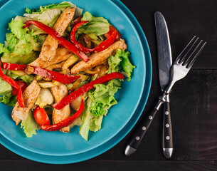 Delicious salad with grilled chicken and red pepper dressing on turquoise plate