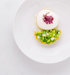 Gourmet appetizer dish with vegetable tartlet and creamy mousse on white plate