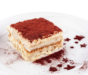 Delicious tiramisu cake with cocoa powder on white plate