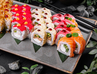 Assorted sushi platter on dark stone background