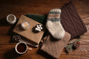 Fototapeta premium Cozy winter evening with hot chocolate, marshmallows, books, and knitted warmth on rustic wooden table
