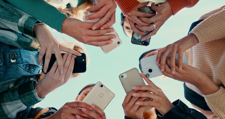 Outdoor, people hands with smartphone for connection, networking and share information for location. Group, friends and solidarity with cellphone for mobile app, download or social media by low angle