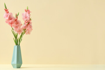 Vase with bouquet of beautiful gladiolus flowers on beige background