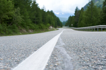 Asphalt road in the mountains with white markings on the asphalt.